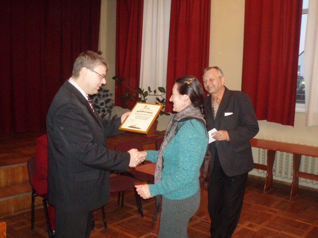 Bauskas pilsētas Domes priekšsēdētājas vietnieks Māris Freimanis (no kreisās) sveic SIA «Bauskas namsaimnieks» čaklo roku turētāju Ņinu Butkeviču. 
Autors: Andra Matuļenko