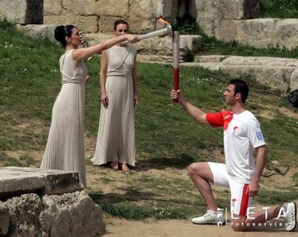 24.03.2008. Grieķu aktrise Marija Nafpliota (no kreisās) tēlo grieķu priesterieni un nodod Olimpisko uguni stafetes pirmajam dalībniekam Aleksandram Nikolaidim, kurš 2004.gada Atēnu olimpiskajās spēlēs ieguva sudraba medaļu taekvondo. 24.martā svinīgi tika iededzināta Pekinas olimpisko spēļu lāpa.
Autors: AFP/LETA