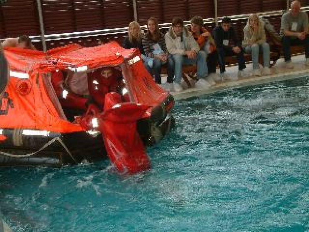 Baseinā trim katras komandas dalībniekiem ar instruktoru palīdzību vajadzēja uzvilkt hidrokostīmus, tajos pa vienam pārpeldēt baseinu un ierāpties glābšanas plostā. 
Autors: www.jurasadministracija.lv