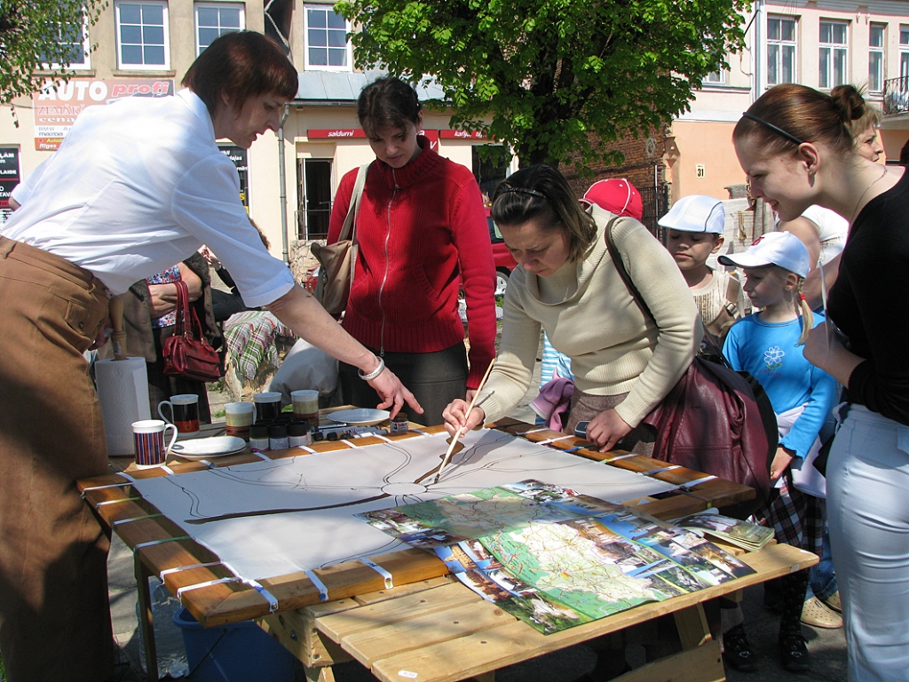 Mākslas salona „Meistars Gothards” vadītāja Indra Liepa (no kreisās)  palīdz rīdziniecei Oksanai Kornouhai rajona kartē atpazīt nozīmīgākos ceļus un upes. 
Autors: Vilnis Auzāns