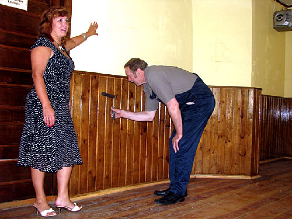 Dzimtmisas pamatskolas direktore Jana Arāja rāda uz lielās zāles drūpošās sienas pirms kāda laika uzlīmētos auduma gabalus, kuri atbilstīgi teicienam «defektu pārvērš par efektu». Vadītājas vietnieks saimnieciskajos jautājumos Jānis Kikusts pārlako dekoratīvās apdares dēlīšus.
Autors: Juris Iļņickis