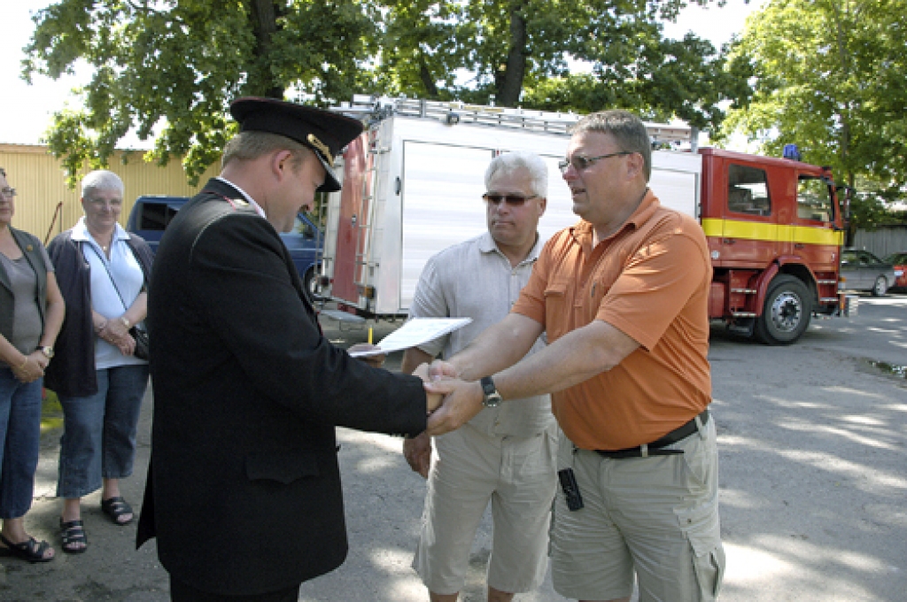 VUGD Bauskas brigādes Iecavas posteņa komandieris Ralfs Šastakovičs (no kreisās)  no Hokana Lundkvista (otrais no kreisās) un Eilerta Heglunda saņem dokumentus, kas apliecina, ka iecavnieku rīcībā turpmāk būs vēls viens zviedru dāvāts ugunsdzēsēju auto. 
Autors: Ivars Bogdanovs