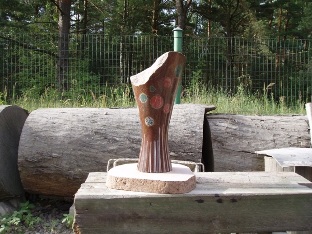 Piemiņas akmens, veltīts Norai Bumbierei. Autors P. Jaunzems.  Ziedu sniegšana skatuves māksliniekam ir kā hrestomātisks atzinības, cieņas un mīlestības apliecinājums. Skulptūrā atveidotā ziedu buķete simbolizē klausītāju pateicību Noras Bumbieres radošajam skatuves mūžam. Nevīstošie ziedi akmenī simboliski izsaka domu, ka Noras dziesmas dzīvo pāri laikam.
Autors: no N. Bumbieres fonda arhīva.