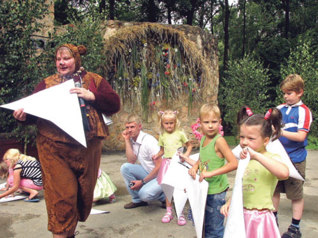 Bērnu pilsētiņas «Gaiļbiksis» iedzīvotājs Lācis (Bauskas pilsētas Tautas nama darbiniece Indra Zviedre) mācīja jaunākajiem Ziedu svētku apmeklētājiem locīt lāča cepures. Tās vasarā ir ļoti noderīgas, lai paslēptos no saules.