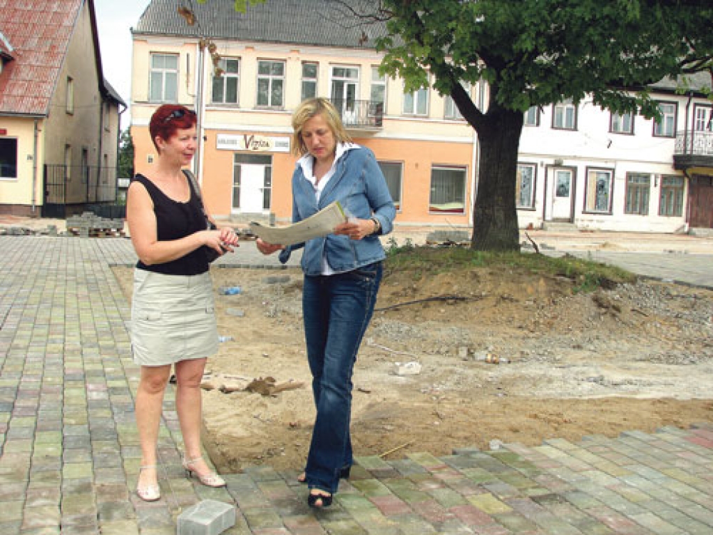 Projekta arhitekte Aija Ziemeļniece (no labās) un Bauskas arhitekte Dace Putna apspriežas, kā Rātslaukumā izvietos jau piegādātos solus. Ap vienīgo laukumā atstāto koku šonedēļ uzmūrēs laukakmeņu valnīti ar koka sēdvietām. 