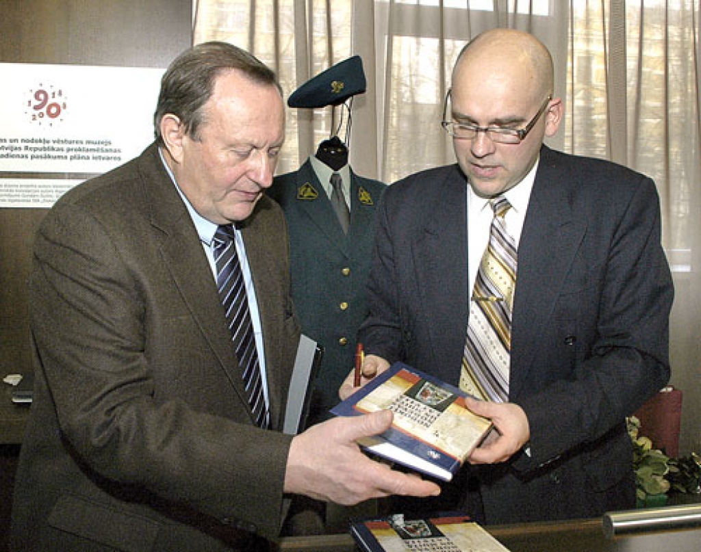 Aigars Urtāns (no labās), skanot Muitnieku maršam, parakstās sarīkojuma viesiem uzdāvinātās grāmatās.
Autors: Ivars Bogdanovs