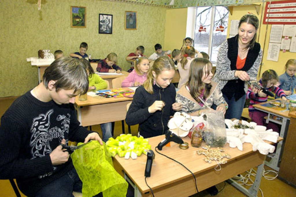 Vecsaules pamatskolas audzēkņi Toms Štrāls (no kreisās), Una Rozentāle un Gune Mīlgrāve veido sniegpārslas, kas nokļūs Rīgā, kur piedalīsies konkursā «Leduspuķes zied». Vizuālās mākslas skolotāja Evita Zeltiņa (no labās) sniedz padomus.