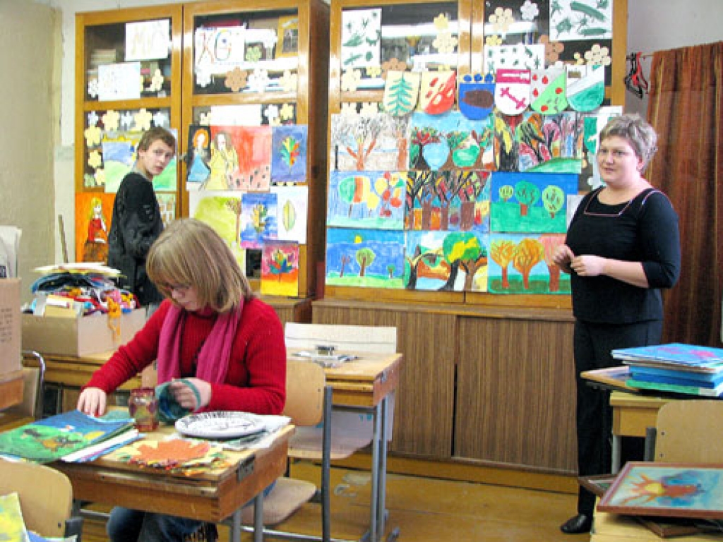 Vizuālās mākslas skolotāja Sigita Lazberga kopā ar 7. klases audzēkņiem Lolitu Emsiņu un Edmundu Plaksu iekārto skolas jubilejai veltītu mākslas izstādi.