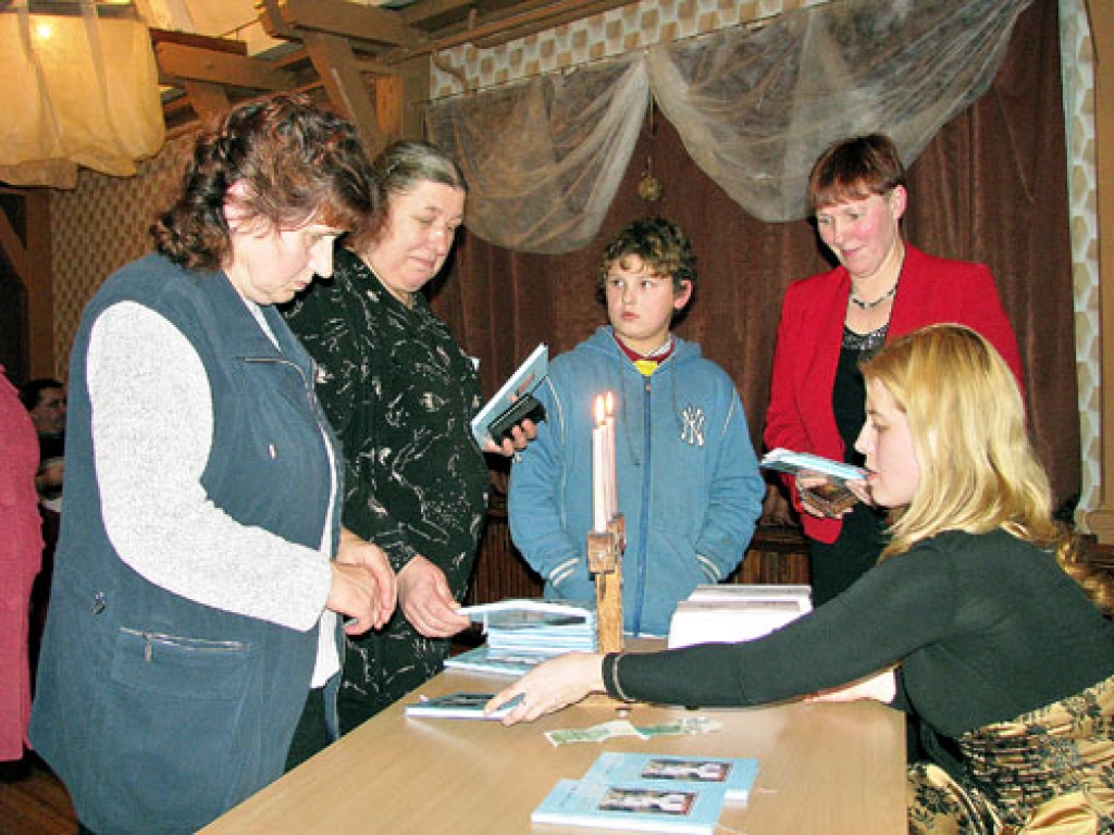 Dzejniece Sarmīte Gausiņa-Elksne sniedz autogrāfus pasākuma «Es – Dieva daļa» dalībniekiem.