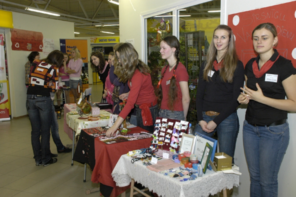 «Junior Achievement–Young Enterprise Latvija» skolēnu mācību firmu pārstāvji Bauskas veikalā «Rimi» piedāvāja savus ražojumus. Rīgas 2. vidusskolas (pirmās no labās) audzēknes Maija un Elīna bija izgatavojušas gan rotaslietas, gan greznus dāvanu maisiņus, kuros tās ievietot. 
Autors: Ivars Bogdanovs