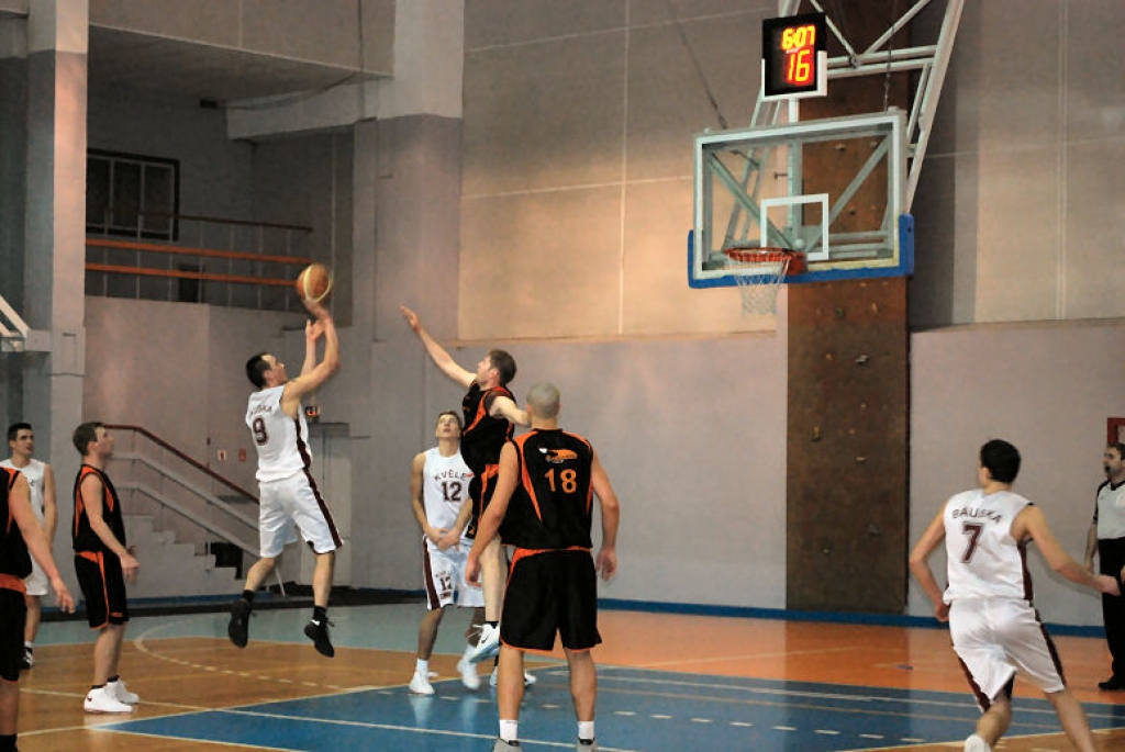 Nauris Metnieks realizē divpunktu metienu. Spēles laikā tuvu pie groza viņu apstādināt bija ļoti grūti. Arī šoreiz viņu nespēja apturēt divus metrus garais un 105 kilogramus smagais «Saulkrastu» vienības «centrs» Artūrs Jēkabsons (18. numurs). 
Autors: Uldis Varnevičs