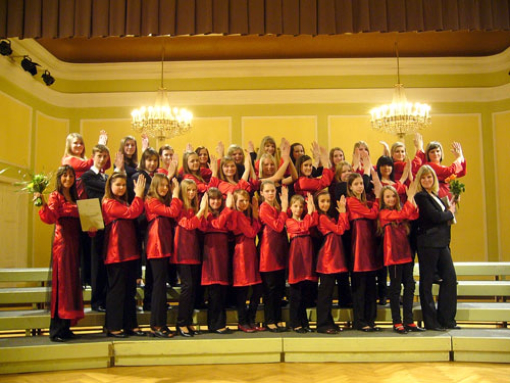 Iecavas mūzikas skolas kora dalībnieču skanīgās balsis sniedza baudījumu ausīm, bet  skaistie tērpi – acīm. Diriģente Madara Strazdiņa – pirmajā rindā no kreisās. Priekšnesumā piedalījās arī koncertmeistare Kristīne Vaičus (no labās).