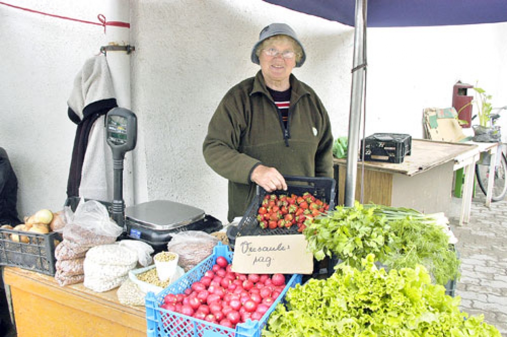 Vecsauliete Elēna Banele saka: «Mēs nedaudz audzējam visu ko.» Viņas uzdevums ir pārdot dārzeņus un augļus.