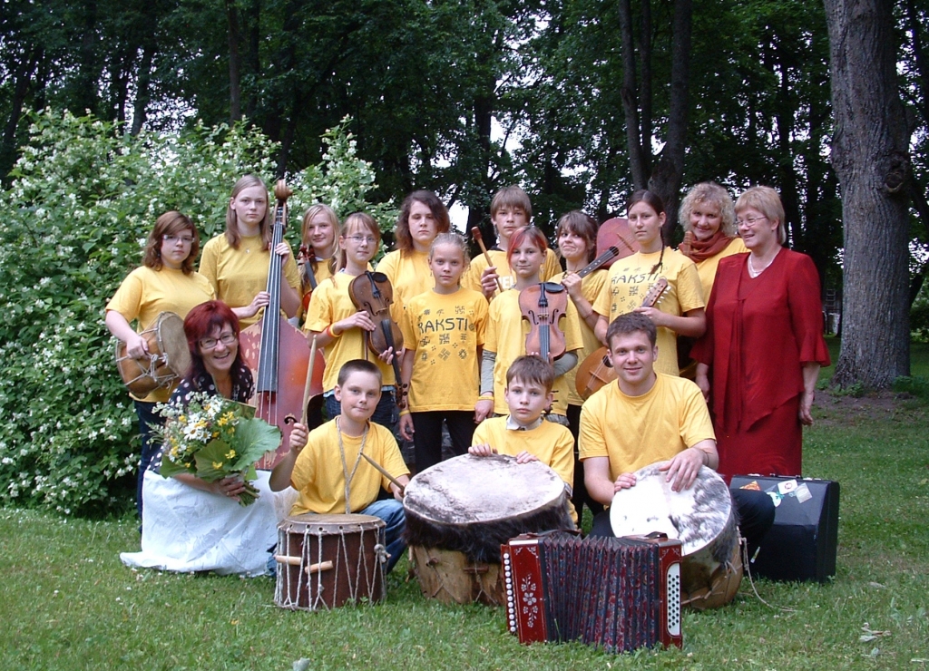 Folkloras kopa «Raksti» no Jēkabpils Vecumniekos viesojās pirmo reizi. Tautas nama vadītāja Valda Kaufmane (pirmajā rindā no kreisās ar ziediem) šo mūziķu uzstāšanos bija vērojusi Bārbelē un abas ar tautas nama mākslinieciskās daļas vadītāju Baibu Škrjabu (otrajā rindā no labās)  nolēmušas viņus uzaicināt uz Vecumniekiem. Grupa izveidota 1992. gadā. Kopš 1993. gada «Rakstus» vada Vita Talla.
Autors: Žanna Zālīte