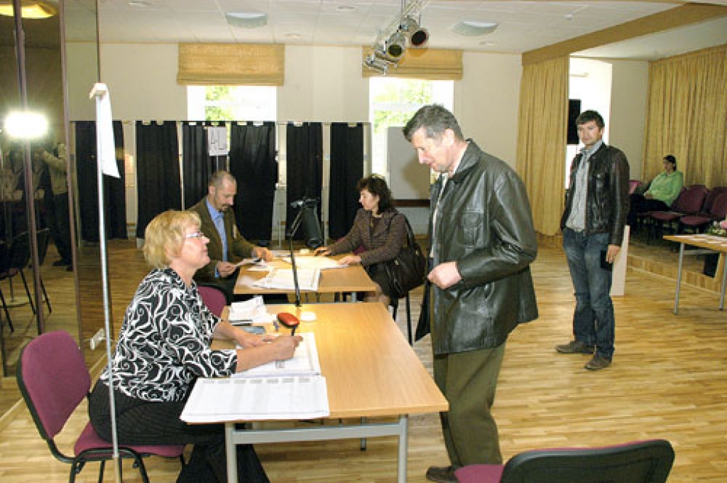 Iecavas novada 350. vēlēšanu iecirkņa komisijas locekļi Maira Māla (no kreisās) un Romualds Latkovskis pieņem Mārtiņa Rāviņa (priekšplānā), Ingas Grīnbergas un Kārļa Bāliņa dokumentus.
Autors: Ivars Bogdanovs