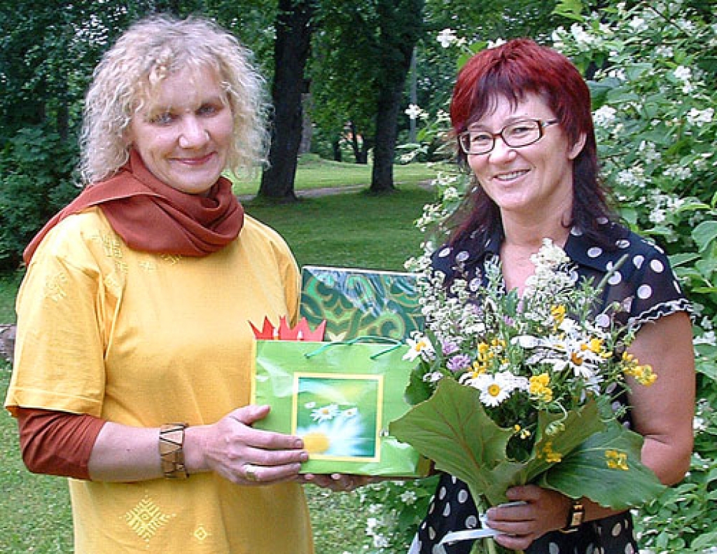 Valda Kaufmane, Vecumnieku tautas nama vadītāja (no labās), ar folk-loras kopas «Raksti» vadītāju Vitu Tallu, kura V. Kaufmanei pasniegusi skaistu puķu pušķi. 