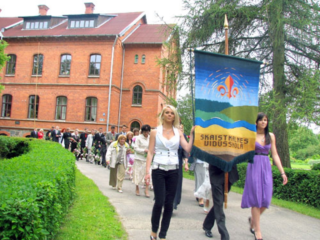 Skaistkalnes vidusskolas absolventi un skolotāji svinīgajā gājienā.
