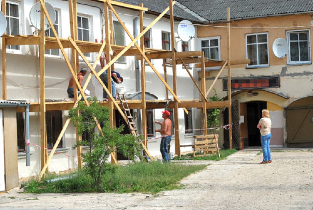 Edīte Auziņa (no labās), mājas pārvaldniece, vēro strādnieku jau paveikto darbu.