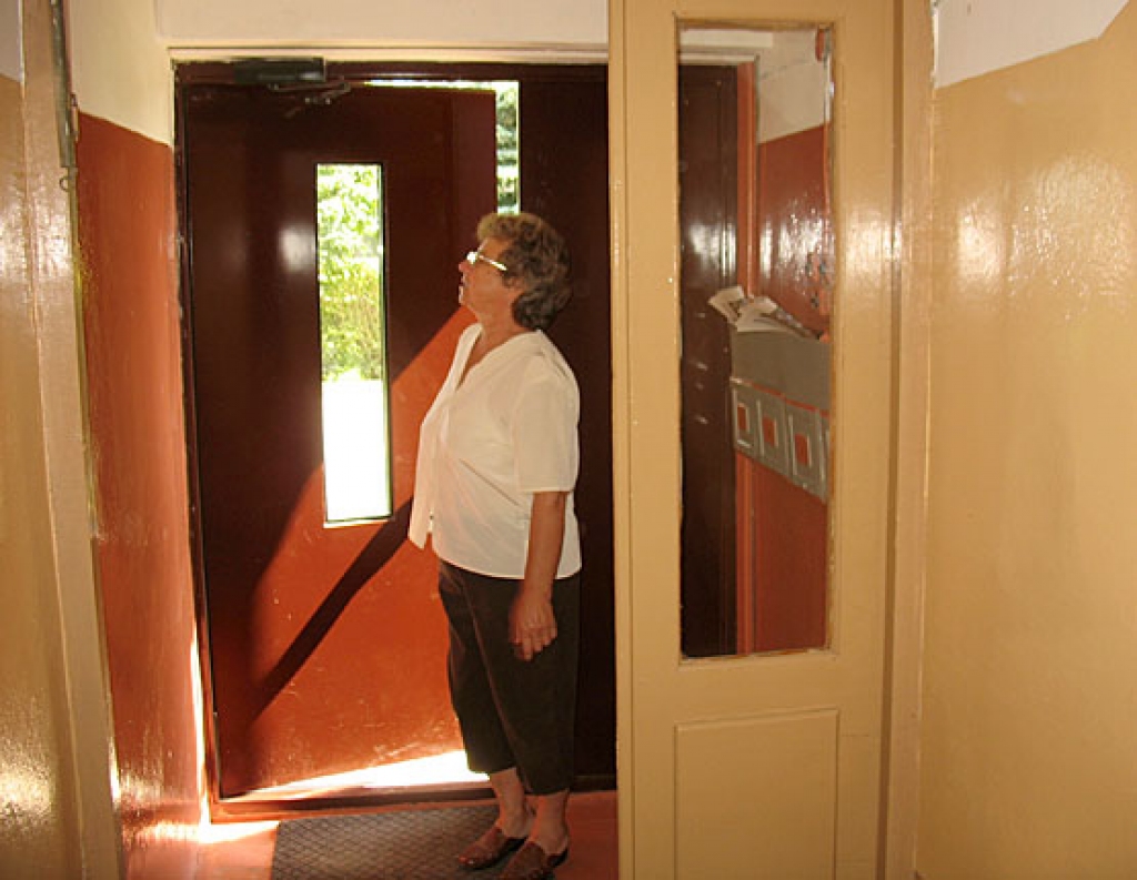 Anna Borkovska rāda jaunās durvis, izremontēto kāpņu telpu. Daļu darba izdevumu finansēti no projekta naudas, daļu iedzīvotāji savākuši paši. 
Autors: Vilnis Auzāns