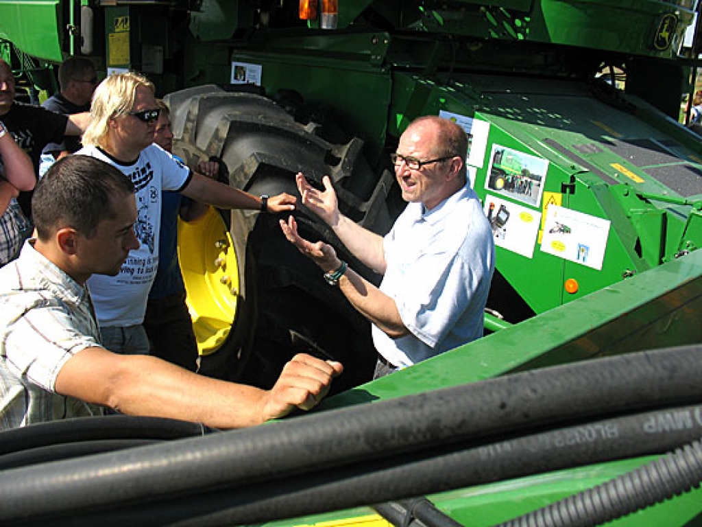 «John Deere» pārstāvis Pīters Bočers (no labās) Latvijas zemniekiem atklāj un raksturo jaunākās paaudzes kombaina priekšrocības. Tam ir divi kuļtrumuļi, kas nodrošina kūluma labāku ražas caurplūdi un tehnikas ražīgāku darbu.
Autors: Vilnis Auzāns