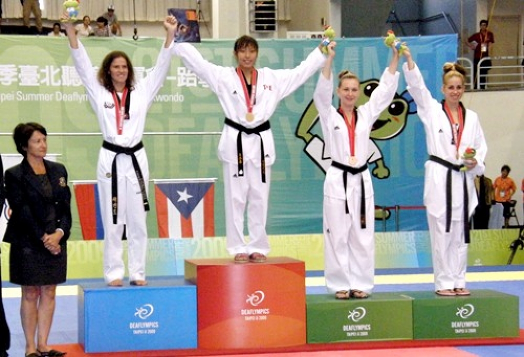 Pasaules 21. nedzirdīgo olimpisko spēļu pjedestāls teikvondo cīņā – 2. vietas ieguvēja īslīciete Laura Gaile. Zelta medaļu ieguva Taivanas pārstāve, bronzas – Krievijas un Puertoriko sportistes. 
Autors: no Lauras Gailes albuma.
