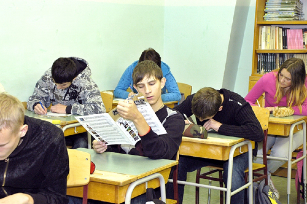 9.b klases skolēni Īslīces vidusskolā tikko saņēmuši anketas un pārskata konkursa jautājumus.