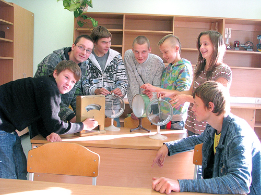 8. klases audzēkņi aplūko mērierīces, ko fizikas stundās savulaik izmantoja viņu vecāki un vecvecāki.