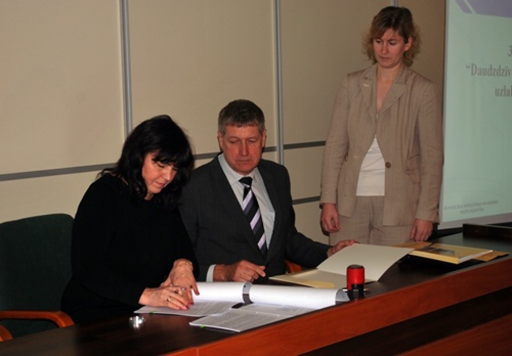 Dzīvokļu īpašnieku kooperatīvās sabiedrības «Neretieši» valdes priekšsēdētāja Anita Savicka (no kreisās) ar parakstu un zīmogu apstiprina līgumu.  Šo mirkli vēro Būvniecības, enerģētikas un mājokļu valsts aģentūras direktors Valdis Blome un komunikāciju nodaļas darbiniece Inese Bērziņa. 
Autors: Uldis Varnevičs