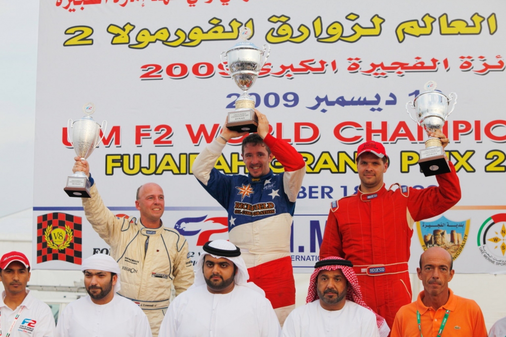 Baušķenieks Uvis Slakteris (otrā rindā no kreisās) uz F-2 pasaules čempionāta goda pjedestāla otrā pakāpiena kopā ar Itālijas sportistu Ivanu Brigadu, kura rezultāts piektajā posmā netika ieskaitīts, kas mainīja pirmās vietas ieguvēju, un tādējādi galveno balvu saņēma Nīderlandes pilots Johans Koenradi, trešajā vietā ierindojās Kolins Dželfs no Lielbritānijas.
Autors: Foto no «Riga Powerboat Team» komandas krājuma.