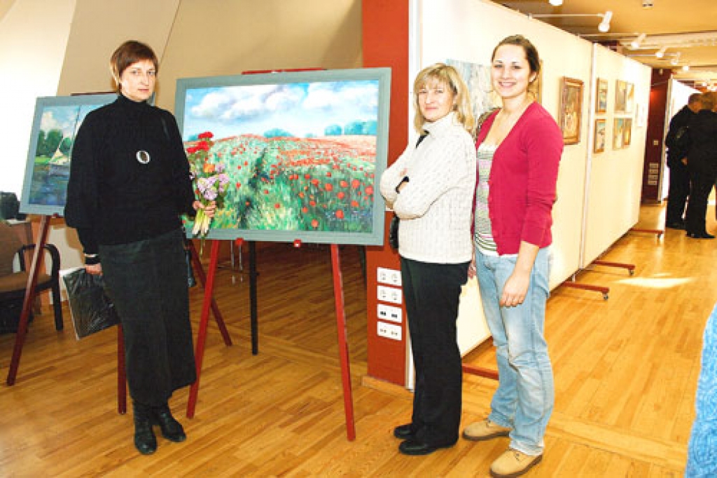 Indra Liepa, salona «Meistars Gothards» vadītāja (no kreisās), Melngalvju nama izstāžu zālē pie Aļģirta Mašala gleznas «Magoņu lauks».
Autors: Ivars Kalniņš