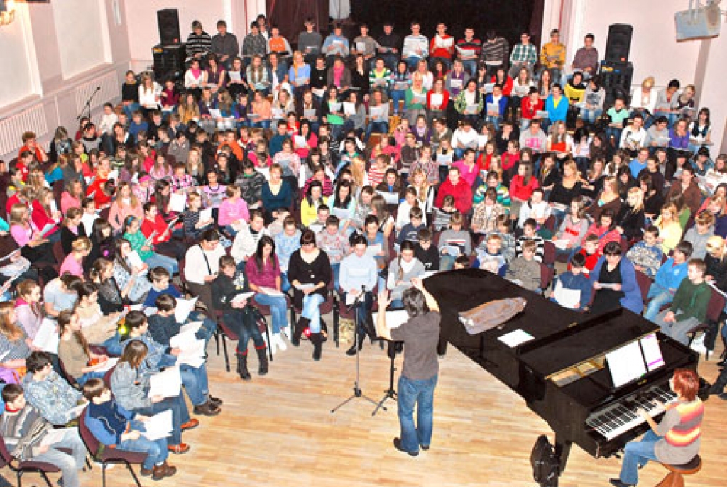 Koru dalībnieki sadalīti balsu grupās, izmēģināja Latvijas skolu jaunatnes dziesmu svētku repertuāru.