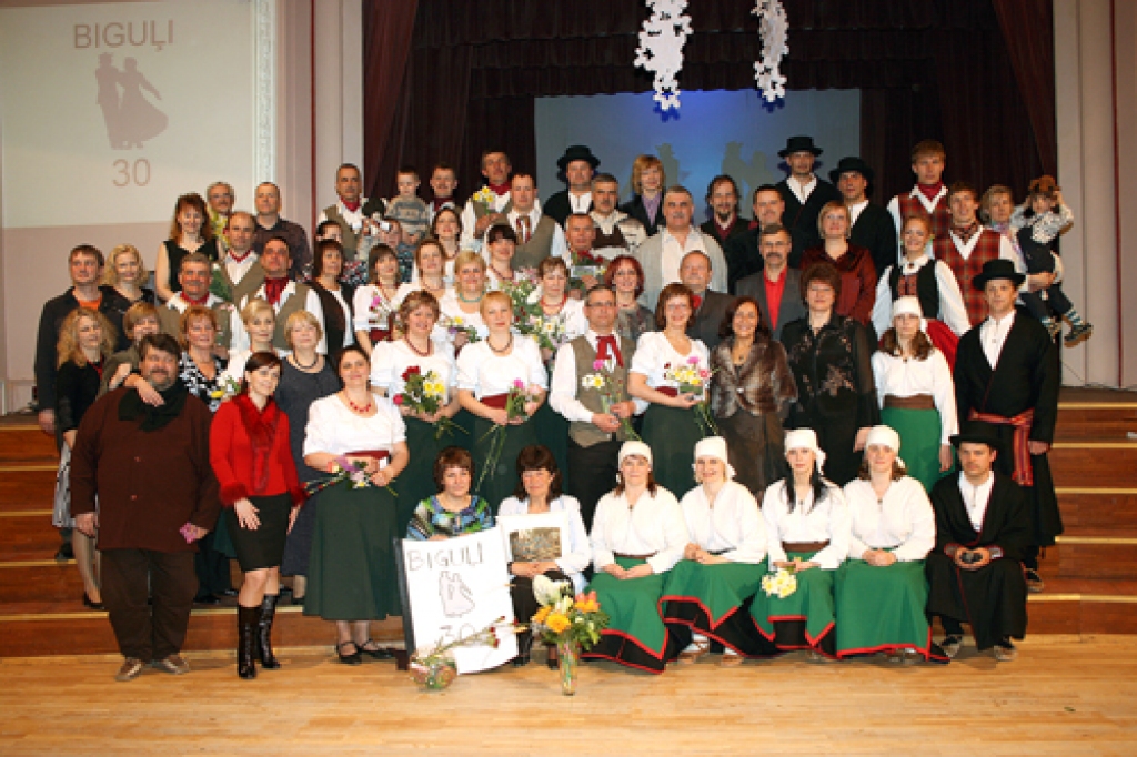 Jubilejas fotoattēlā deju kopas «Biguļi» pašreizējie un kādreizējie dalībnieki, priekšplānā vidū – vadītāja Gunta Sirmele (no kreisās) un koncertmeistare Silvija Geiba.