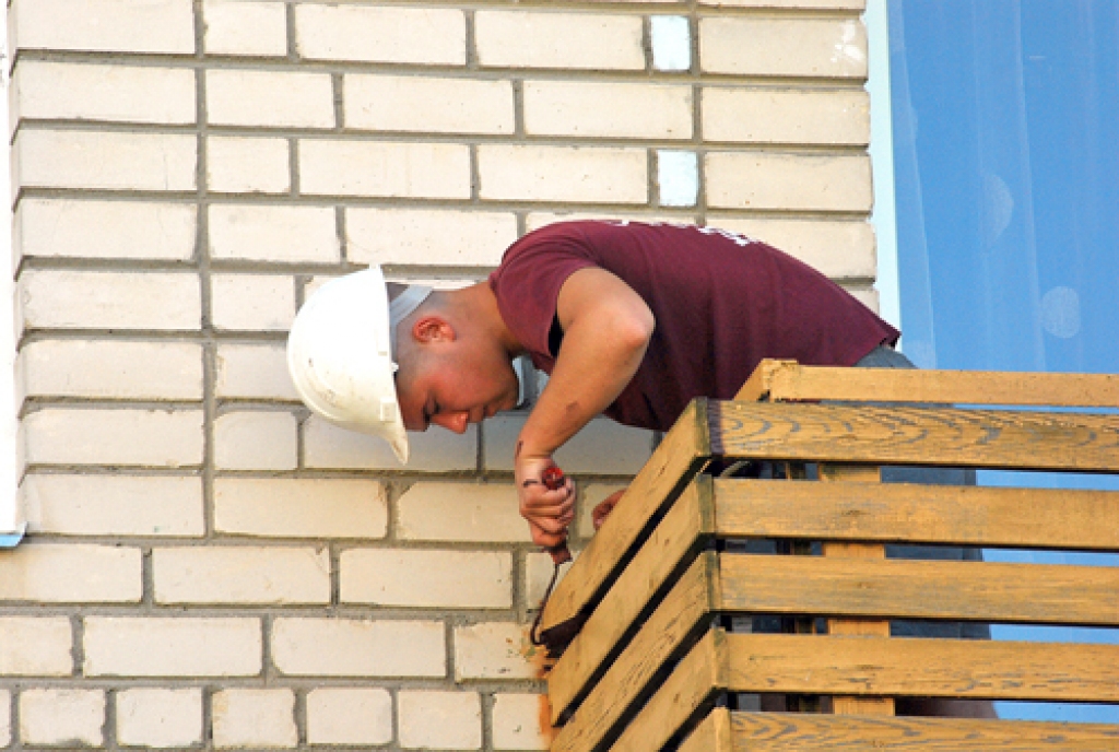 SIA «Bauskas namsaimnieks» strādnieks Gints Kiseļevs krāso balkona koka konstrukcijas Dārza ielā 18. 
Autors: Uldis Varnevičs