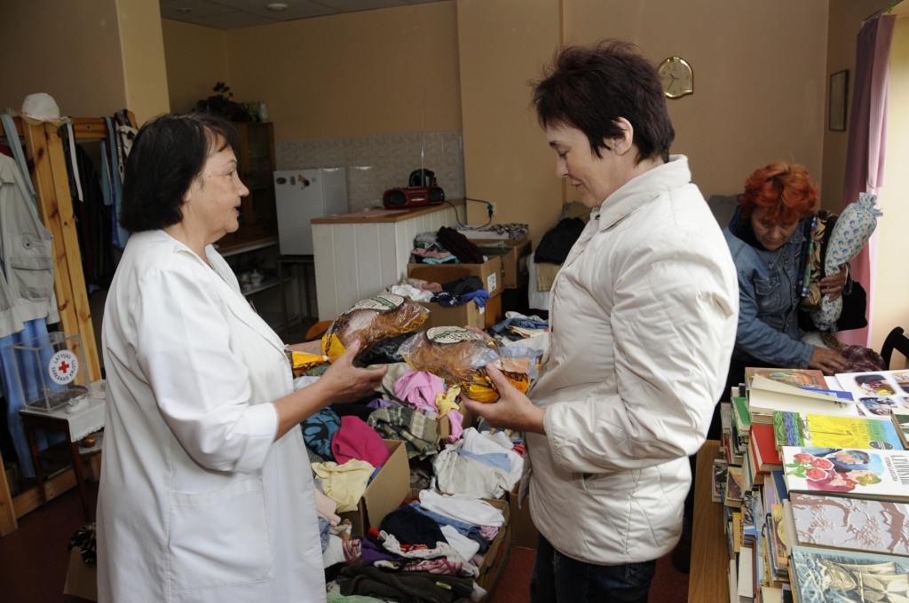 Vera Bajāre (no kreisā) Sarkanā Krusta Bauskas komitejas telpās izdala bezmaksas maizi. Klaipiņš saldskābmaizes tiek Gaļinai Čirkstei, to saņems arī Ludmila Buķele. 
Autors: Ivars Bogdanovs