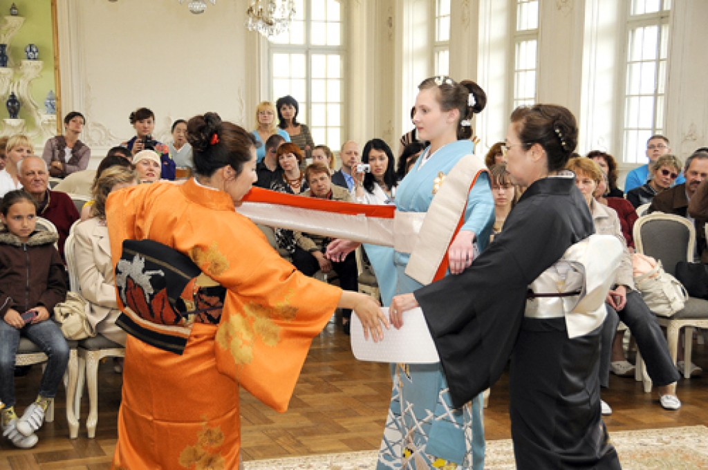 Kunitači pilsētas tradīciju grupas dalībnieces un Rīgas japāņu valodas un kultūras studijas «Gengo» skolniece rāda, kā pareizi uzvilkt tradicionālo japāņu apģērbu – kimono.
