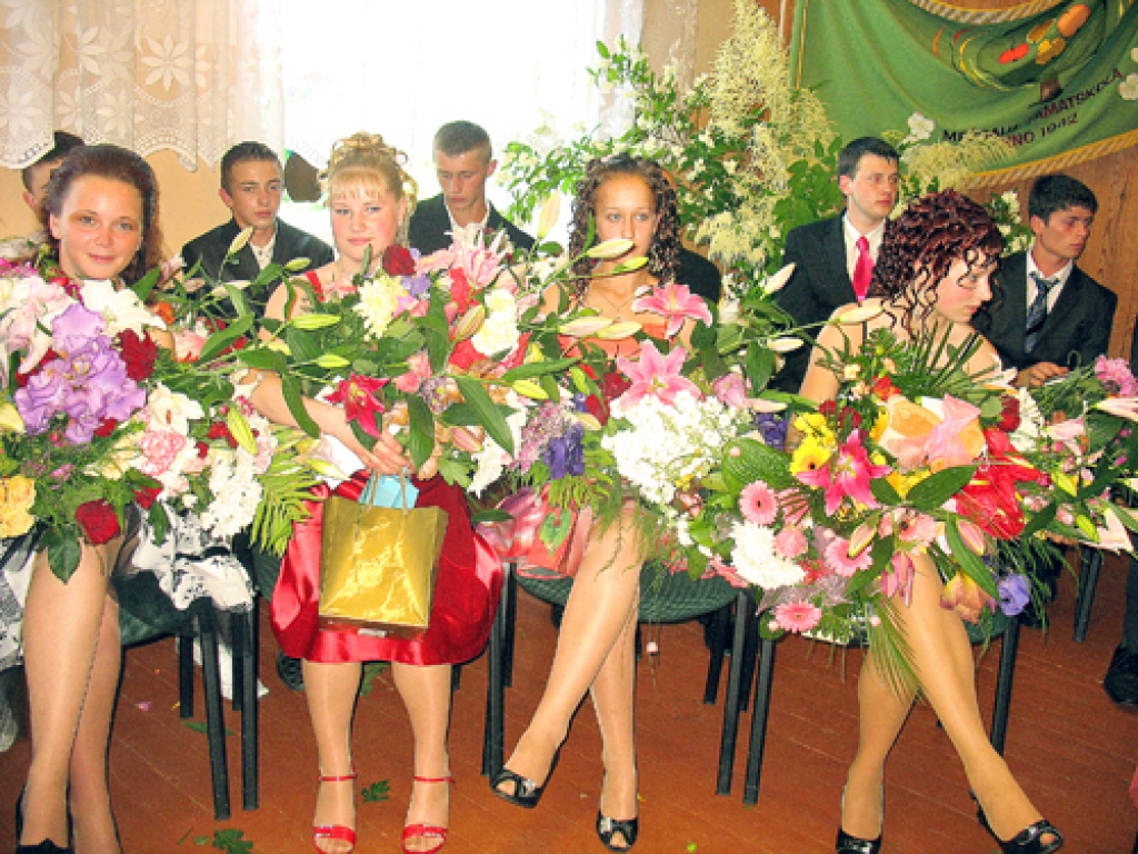 Mežgaļu pamatskolas absolventes ziedu jūrā.