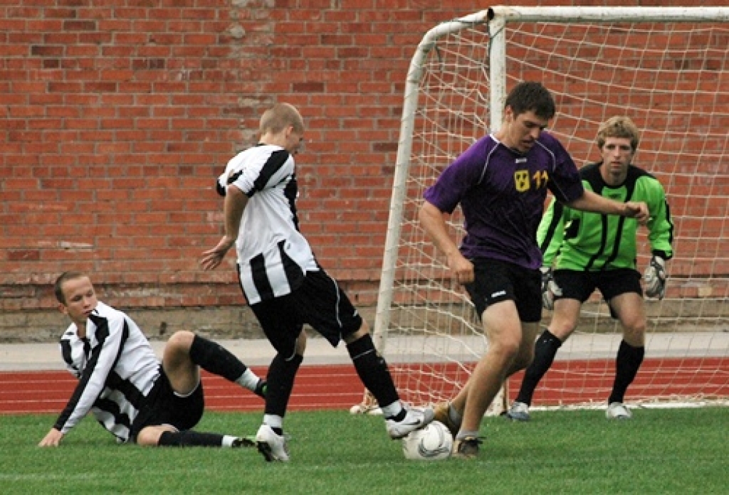 «Īslīces» futbolisti (balti melnajos tērpos) mēģina apturēt «Gailīšu» uzbrucēju pie saviem vārtiem. 
Autors: Uldis Varnevičs