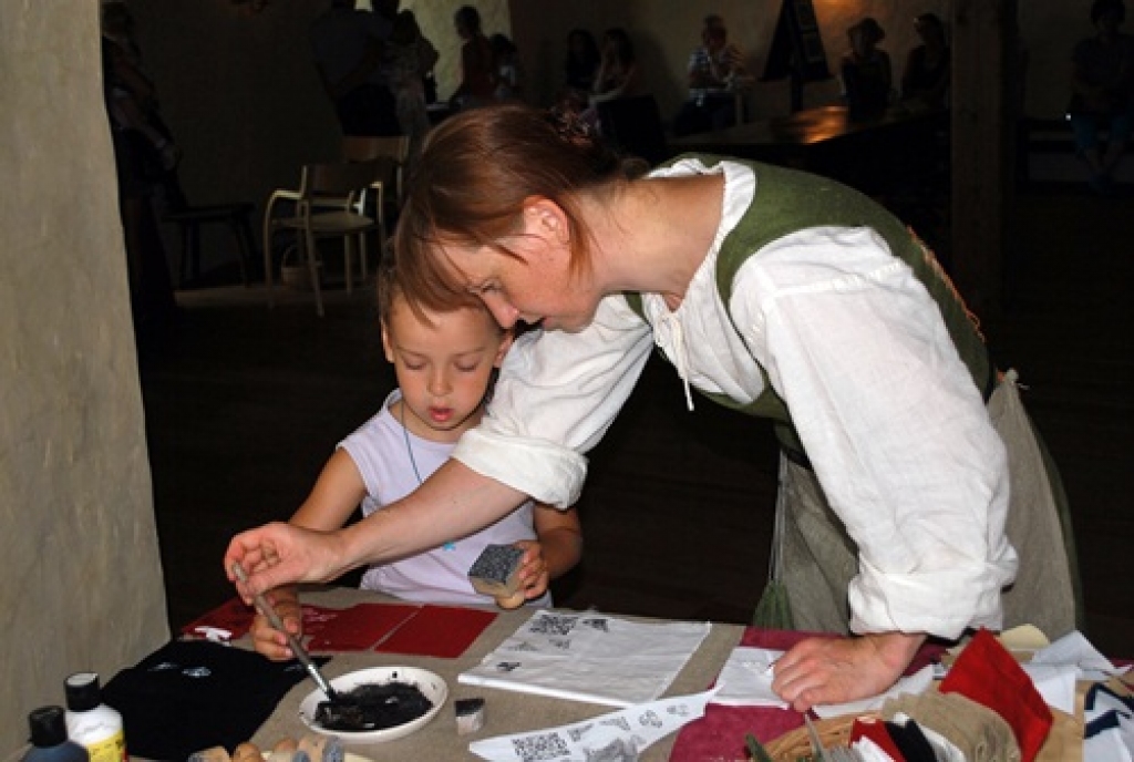 Agate Vītola (no labās) māca Paulai Sipovičai, kā precīzi uzspiest zīmogu uz maciņa, lai neizķēpātu ornamentu.
Autors: Uldis Varnevičs