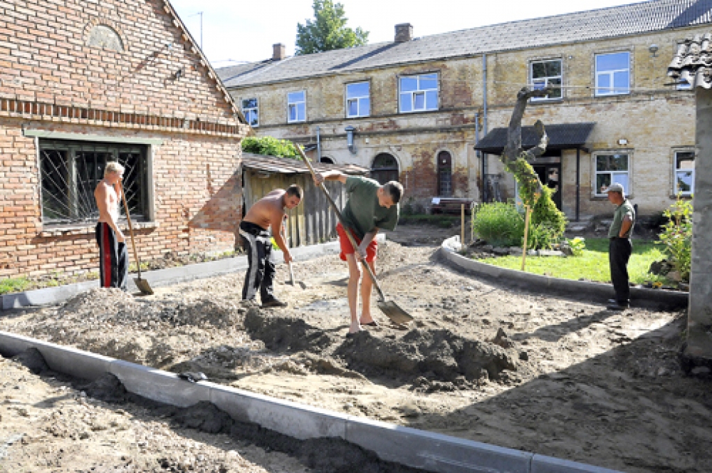 SIA «Viona» strādnieki gatavo pamatus bruģējamam celiņam Pamūšas speciālās internātpamatskolas  teritorijā. 