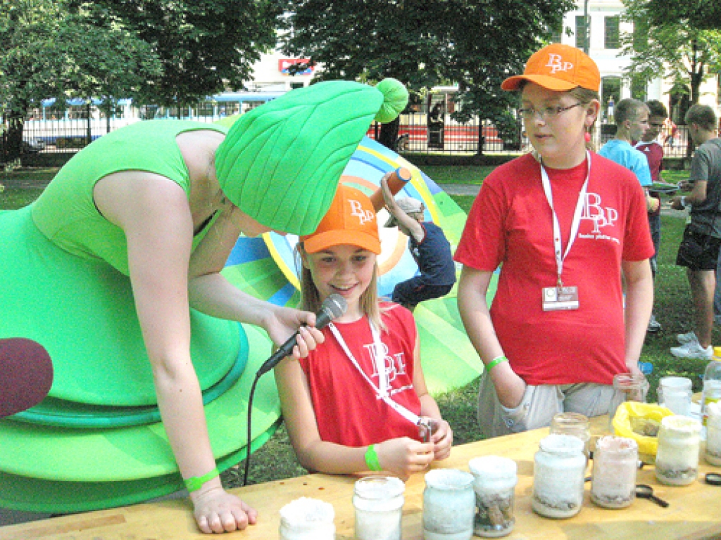 Bauskas pamatskolas 4. klases meitenes Elisone Kriščune (no labās) un Baiba Betija Saulīte neapmulsa, kad Dziesmu un deju svētku simbols Vilciņš sāka uzdot jautājumus par eksperimentu «Sāls kristālu iegūšana».