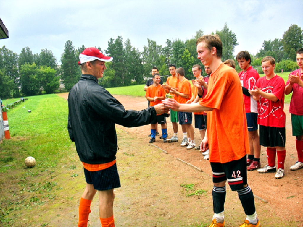 Vecumnieku novada sporta spēļu futbola sacensību galvenais tiesnesis Gatis Upelnieks (no kreisās) apbalvo mājinieku komandas kapteini Eināru Borisovu par iegūto trešo vietu, kuru nodrošināja vārtsarga Artūra Černišova veiksmīga spēle.
Autors: Mārīte Ozoliņa.