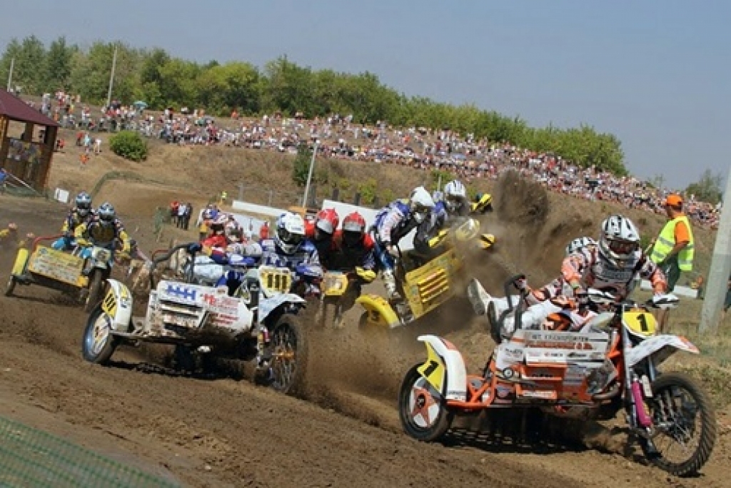 Nīderlandiešu Jana un Jeroena Višeru ekipāža (sarkanajās ķiverēs) pēc starta pirmajā līkumā izspieda Jāņa Daidera un Elvija Mucenieka (dzeltenais motocikls ar 3. numuru) ekipāžu uz trases apmales. 
Autors:  picasaweb.google.com