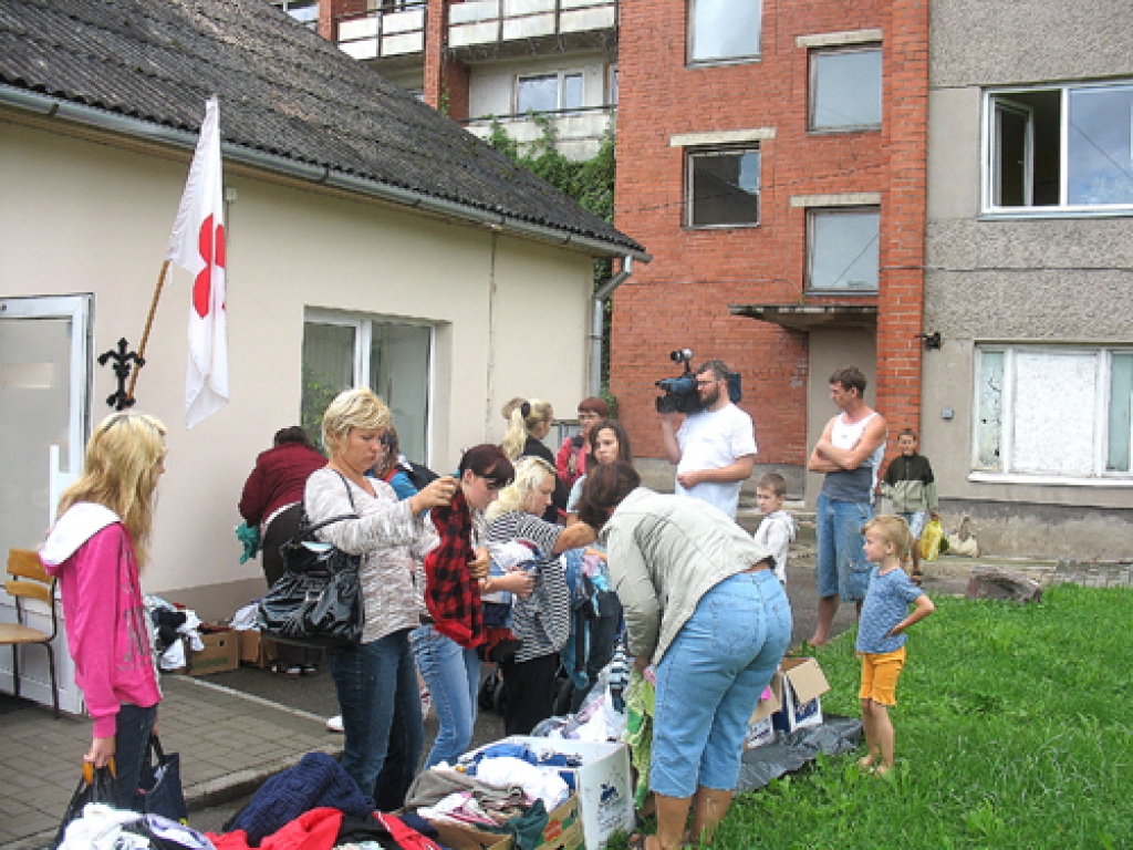 Pie Sarkanā Krusta telpām ceturtdien jau pirms pulksten 9 pulcējās cilvēki. Palīdzībai paredzētās lietas bija izliktas ne tikai ēkā, bet arī laukā. Reģistrējoties pie žēlsirdīgās māsas Veras Bajāres, katra ģimene varēja izvēlēties sev noderīgo.