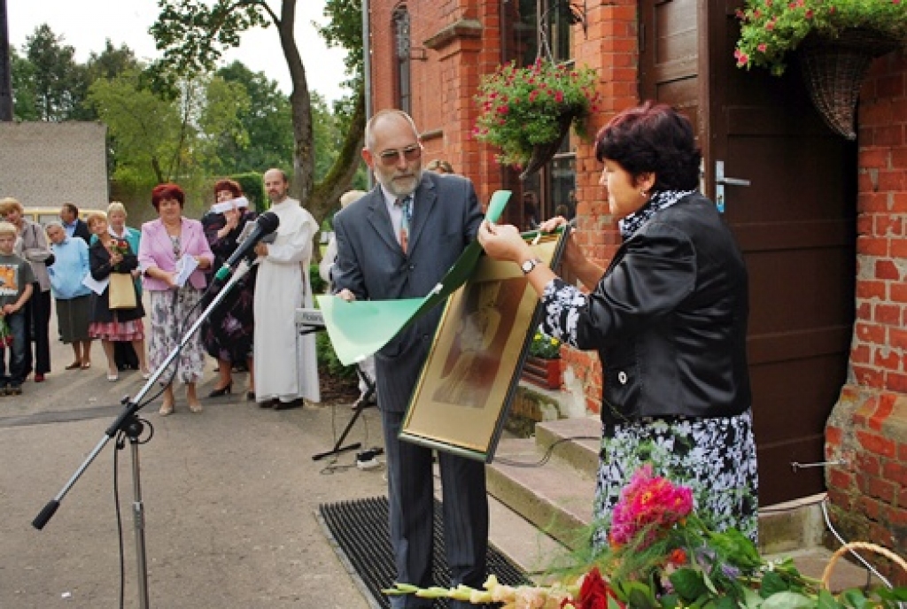 Skaistkalnes vidusskolas direktore Svetlana Vāverniece un Gunārs Silakaktiņš atklāj klātesošajiem skolas ēkas projektētāja Maksa Paula Berči portretu. 
Autors: Uldis Varnevičs