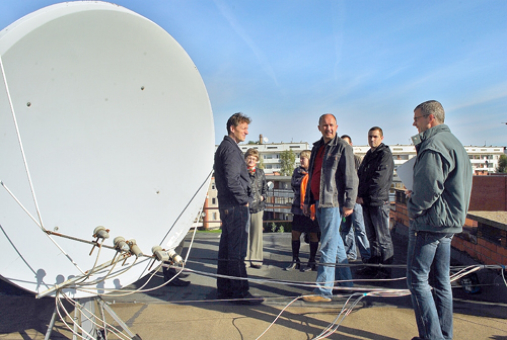 Iniciatīvas «Mājas draugs» dalībnieki Bauskā novērtē Zaļās ielas 6. mājas jumtu. Viesus no Vācijas izbrīnīja uz jumta novietotā lielā satelīttelevīzijas antena. 