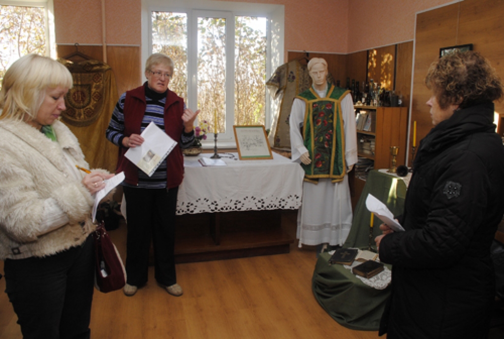 Skaistkalnes pagasta muzejā par vietējo kultūrvēsturi aizrautīgi stāsta Brigita Gedrovica (vidū), ieinteresētas klausītājas ir Hipotēku bankas Korporatīvo attiecību daļas vadītāja Anita Šalme (no kreisās) un šīs bankas Bauskas filiāles vadītāja Māra Bite. Uz apmeklētājiem «noraugās» katoļu priestera drānās (zaļā ornātā) tērptais manekens, kas iegādāts par Hipotēku bankas projektā piešķirto naudu.
Autors: Ivars Bogdanovs