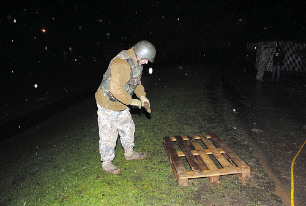 Aigars Circenis, NBS Zemessardzes 54. inženiertehniskā bataljona nesprāgušās munīcijas neitralizēšanas rotas kaprālis, izpētījis Bauskas pirmsskolas izglītības iestādes «Zīlīte» teritorijā atrasto lādiņu, gatavojas tā pārvietošanai.