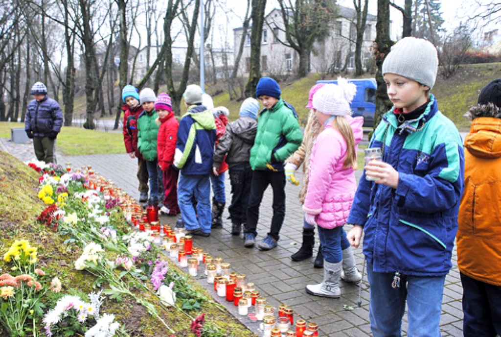 Bauskas 2. vidusskolas 2.a klases audzēkņi kopā ar audzinātāju Ingu Golovčansku aizdedzina svecītes, lai novietotu tās pie Brīvības pieminekļa Bauskā.