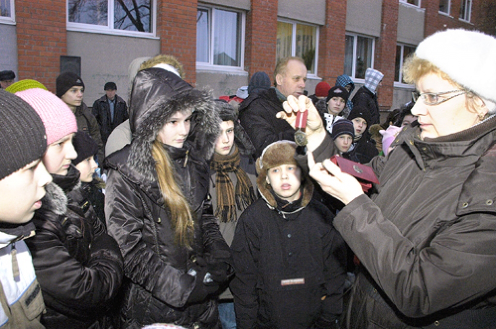 Bauskas pamatskolas audzēkņi ar interesi aplūko Barikāžu dalībnieka piemiņas zīmi, ko viņiem rāda skolotāja Iveta Semjonova.