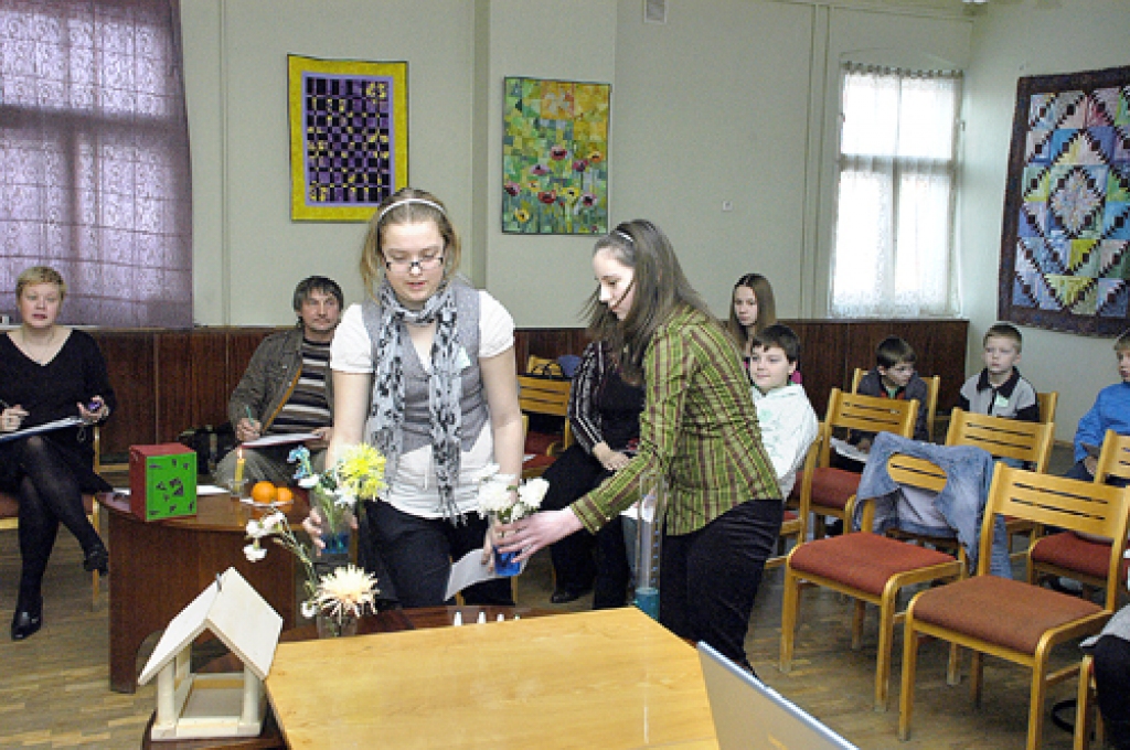 Bauskas pilsētas pamatskolas 5.a klases audzēknes Elisone Kriščune (no kreisās) un Karolīna Auziņa demonstrēja, kā mainās ziedi, ja tos ieliek krāsainā ūdenī.